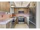 Modern kitchen featuring wooden cabinets, stainless steel appliances, and marble countertops at 5801 E Surrey Dr, Cave Creek, AZ 85331