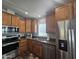 Well-lit kitchen featuring stainless steel appliances, wood cabinets, and modern fixtures at 650 N Hawes Rd # 3604, Mesa, AZ 85207