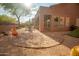 Expansive backyard featuring desert landscaping, a covered patio with outdoor seating, and native plants at 7413 E Russet Sky Dr, Scottsdale, AZ 85266