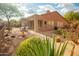 Desert backyard with a tiled patio and outdoor seating area, surrounded by mature desert landscaping at 7413 E Russet Sky Dr, Scottsdale, AZ 85266