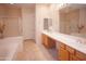 Bright bathroom featuring double sinks, separate glass shower, and soaking tub at 7413 E Russet Sky Dr, Scottsdale, AZ 85266