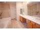 Bright bathroom featuring a garden tub, glass-enclosed shower, and double sink vanity at 7413 E Russet Sky Dr, Scottsdale, AZ 85266