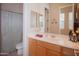 Cozy bathroom featuring a wood vanity, framed mirror, and shower with a silver curtain and tile flooring at 7413 E Russet Sky Dr, Scottsdale, AZ 85266