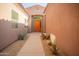 Covered walkway to a stylish front door, complemented by desert landscaping and neutral-toned exterior walls at 7413 E Russet Sky Dr, Scottsdale, AZ 85266