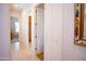 Neutral hallway with tile floors and multiple doors leading to various rooms with a decorative picture frame at 7413 E Russet Sky Dr, Scottsdale, AZ 85266
