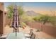 Cozy patio area with a table set, desert landscaping, and views of the majestic mountain range at 7413 E Russet Sky Dr, Scottsdale, AZ 85266