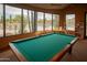 Bright recreation room with a pool table and scenic views of the pool and desert landscape, ideal for relaxation at 7413 E Russet Sky Dr, Scottsdale, AZ 85266