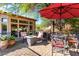 This backyard features a brick patio with a fire pit, desert landscaping, multiple seating areas and trees at 7939 E Stonecliff Cir, Mesa, AZ 85207