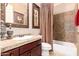 This bathroom features a single sink vanity, tiled countertops, framed mirror, and a tiled bathtub with shower at 7939 E Stonecliff Cir, Mesa, AZ 85207