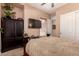Bedroom features a dark wood armoire, television, and closet at 7939 E Stonecliff Cir, Mesa, AZ 85207