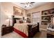 Comfortable bedroom featuring a dark wood bed frame, neutral walls, and built-in shelving at 7939 E Stonecliff Cir, Mesa, AZ 85207