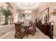 Dining room showcasing a glass table, floral chairs, chandelier lighting, and elegant decor at 7939 E Stonecliff Cir, Mesa, AZ 85207