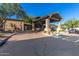 Community entrance featuring covered drop-off area, desert landscaping and ample parking at 7939 E Stonecliff Cir, Mesa, AZ 85207