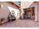 Beautiful courtyard featuring a stone fountain, statue, potted plants, and a striking wood front door at 7939 E Stonecliff Cir, Mesa, AZ 85207
