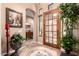 Elegant foyer with decorative flooring, a wood and glass door, arched entryway, and tasteful decor at 7939 E Stonecliff Cir, Mesa, AZ 85207