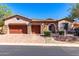 Charming single-story home with stone accents, a tile roof, a three-car garage, and attractive desert landscaping at 7939 E Stonecliff Cir, Mesa, AZ 85207