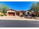 Inviting single-story home featuring a three-car garage, brick driveway, stone accents, and well-maintained desert landscaping at 7939 E Stonecliff Cir, Mesa, AZ 85207