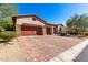 Beautiful home with a three-car garage, brick driveway, arched entryway, and mature landscaping at 7939 E Stonecliff Cir, Mesa, AZ 85207