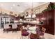 Open kitchen area with dark wood cabinetry, granite counters, a breakfast bar, and a dining area at 7939 E Stonecliff Cir, Mesa, AZ 85207