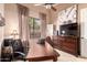 Spacious office featuring a dresser, dark wooden desk, neutral walls, and large window at 7939 E Stonecliff Cir, Mesa, AZ 85207