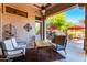 Covered patio features comfortable seating, a ceiling fan, and views of the backyard and pool at 7939 E Stonecliff Cir, Mesa, AZ 85207