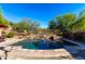 Backyard pool has stone accents and a water feature, set against a desert landscape at 7939 E Stonecliff Cir, Mesa, AZ 85207