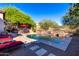 Backyard pool with stone accents, lounge chairs, and patio furniture, perfect for outdoor relaxation at 7939 E Stonecliff Cir, Mesa, AZ 85207