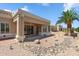 Covered patio surrounded by desert landscaping and a mature palm tree at 8426 W Utopia Rd, Peoria, AZ 85382
