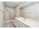 Bathroom featuring a single sink vanity and a shower-tub combo with glass doors at 8426 W Utopia Rd, Peoria, AZ 85382