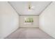 Bedroom with neutral carpet, a ceiling fan, light walls, and large window for natural light at 8426 W Utopia Rd, Peoria, AZ 85382