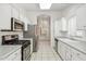Well-lit kitchen featuring stainless steel appliances, white cabinetry, and a skylight at 8426 W Utopia Rd, Peoria, AZ 85382