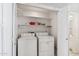 Functional laundry closet with a washer and dryer and some shelving at 8426 W Utopia Rd, Peoria, AZ 85382
