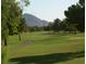 Beautiful golf course view with mature trees and Camelback Mountain in the background at 8626 E Irish Hunter Trl, Scottsdale, AZ 85258