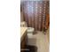 Cozy bathroom featuring patterned shower curtain, gray tile floor and neutral color palette at 962 S Main Dr, Apache Junction, AZ 85120