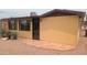 Cozy home featuring a secure screened door, tiled patio area, and xeriscaped front yard for easy maintenance at 962 S Main Dr, Apache Junction, AZ 85120