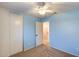 Carpeted bedroom features a ceiling fan and a door to a nearby bathroom at 10557 W Louise Dr, Peoria, AZ 85383