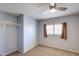 Simple carpeted bedroom with an exposed closet bar and a window with blinds at 10557 W Louise Dr, Peoria, AZ 85383