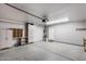 Organized garage with storage cabinets, overhead lighting, and epoxy-coated flooring at 10557 W Louise Dr, Peoria, AZ 85383