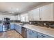 Modern kitchen with stainless appliances, blue base cabinets, and updated countertops at 10557 W Louise Dr, Peoria, AZ 85383