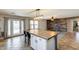 Bright eat-in kitchen featuring an island with bar seating, stylish lighting, and doors to the outdoor pool at 10557 W Louise Dr, Peoria, AZ 85383