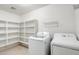 Bright laundry room with storage shelves, washer, and dryer for added convenience at 10557 W Louise Dr, Peoria, AZ 85383