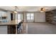 Open-concept living space with wood-look accent wall, plush carpet, and convenient kitchen access at 10557 W Louise Dr, Peoria, AZ 85383