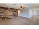 Large living room featuring a wood accent wall, neutral paint, and transitional tile flooring at 10557 W Louise Dr, Peoria, AZ 85383