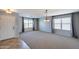 Comfortable living room with neutral carpet, two windows, and a glimpse into the kitchen at 10557 W Louise Dr, Peoria, AZ 85383
