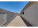 Side yard with gravel and privacy wall plus access gate to the front of the home at 10557 W Louise Dr, Peoria, AZ 85383