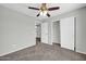 Neutral bedroom features a ceiling fan, gray walls, carpet, and access to the closet and hallway at 11154 W Ashley Chantil Dr, Surprise, AZ 85378