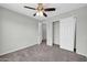 Neutral bedroom features a ceiling fan, gray walls, carpet, and access to the closet and hallway at 11154 W Ashley Chantil Dr, Surprise, AZ 85378