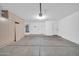 A spacious garage with painted walls, concrete flooring, storage cabinets, and a mounted water heater at 11154 W Ashley Chantil Dr, Surprise, AZ 85378