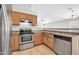 Functional kitchen with stainless steel appliances, wooden cabinets, and an adjacent dining area at 11154 W Ashley Chantil Dr, Surprise, AZ 85378