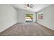 Spacious living room featuring carpet flooring, neutral paint, a ceiling fan, and sliding glass doors at 11154 W Ashley Chantil Dr, Surprise, AZ 85378
